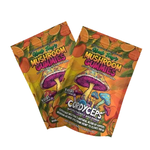 Two packages of "Uncle Frog's Mushroom Gummies" with vibrant, colorful packaging featuring illustrations of mushrooms and a tropical theme. The text highlights "CORDYCEPS," "Natural Energy and Power," and "Experience the Multiverse with Earth's Finest Hemp," suggesting health and vitality benefits. The gummies are mango-flavored and boast a "1000 mg Active PER SERVE" designation, emphasizing their potency.