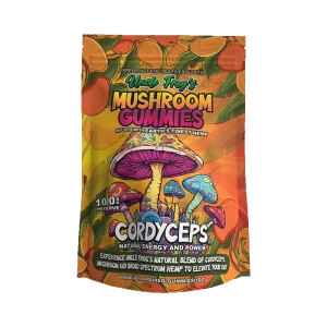 The image shows a product packaging design for "Uncle Frog's MUSHROOM GUMMIES," which are described as being infused with "Earth's finest hemp." The packaging is vibrant and colorful, with illustrations of various mushrooms, including a prominent one with a blue cap and pinkish underside at the center. Below the mushrooms, there is a bold text that reads "CORDYCEPS" followed by "NATURAL ENERGY AND POWER," indicating the type of mushrooms or the intended effect of the gummies. Additional text explains that the product includes a "natural blend of cordyceps mushroom and broad spectrum hemp to elevate your day." At the bottom, it is noted that the package contains "8 mango flavored gummies (1 oz)." The design is very much in the style of psychedelic artwork, with rich colors and a busy, illustrative style that suggests a natural, energetic experience.